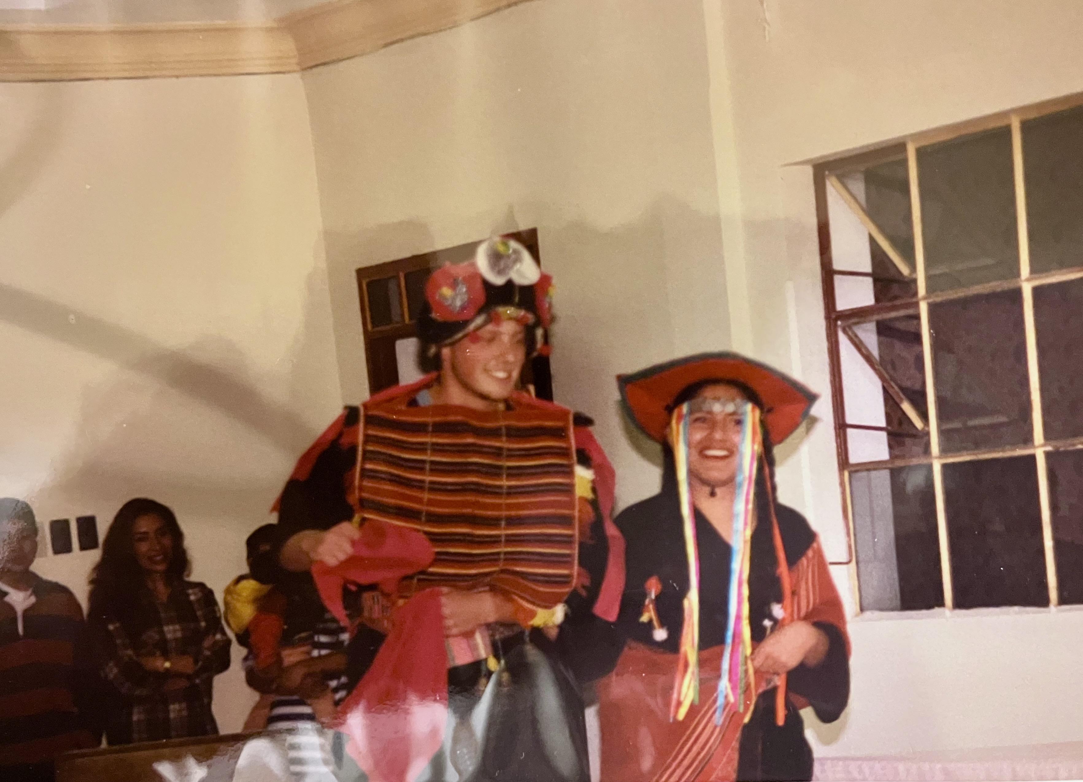 Jason and a friend wearing traditional Bolivian attire during a cultural presentation.