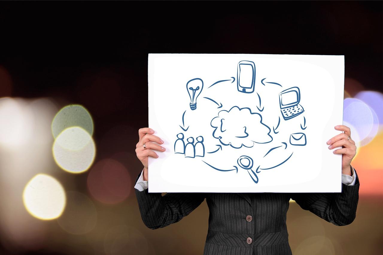 man holding large paper showing digital elements drawn