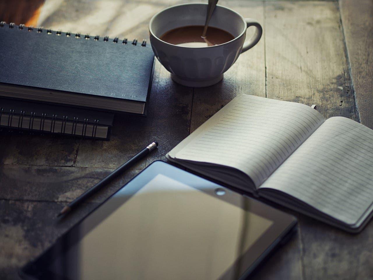 an open book, and ipad, and coffee cup